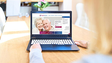 Eine Frau schaut sich auf einem Laptop das Pflege Service Portal unter www.pflegeberatung.de an.