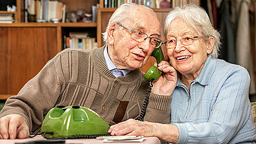 Ein älteres Paar am Telefonhörer.